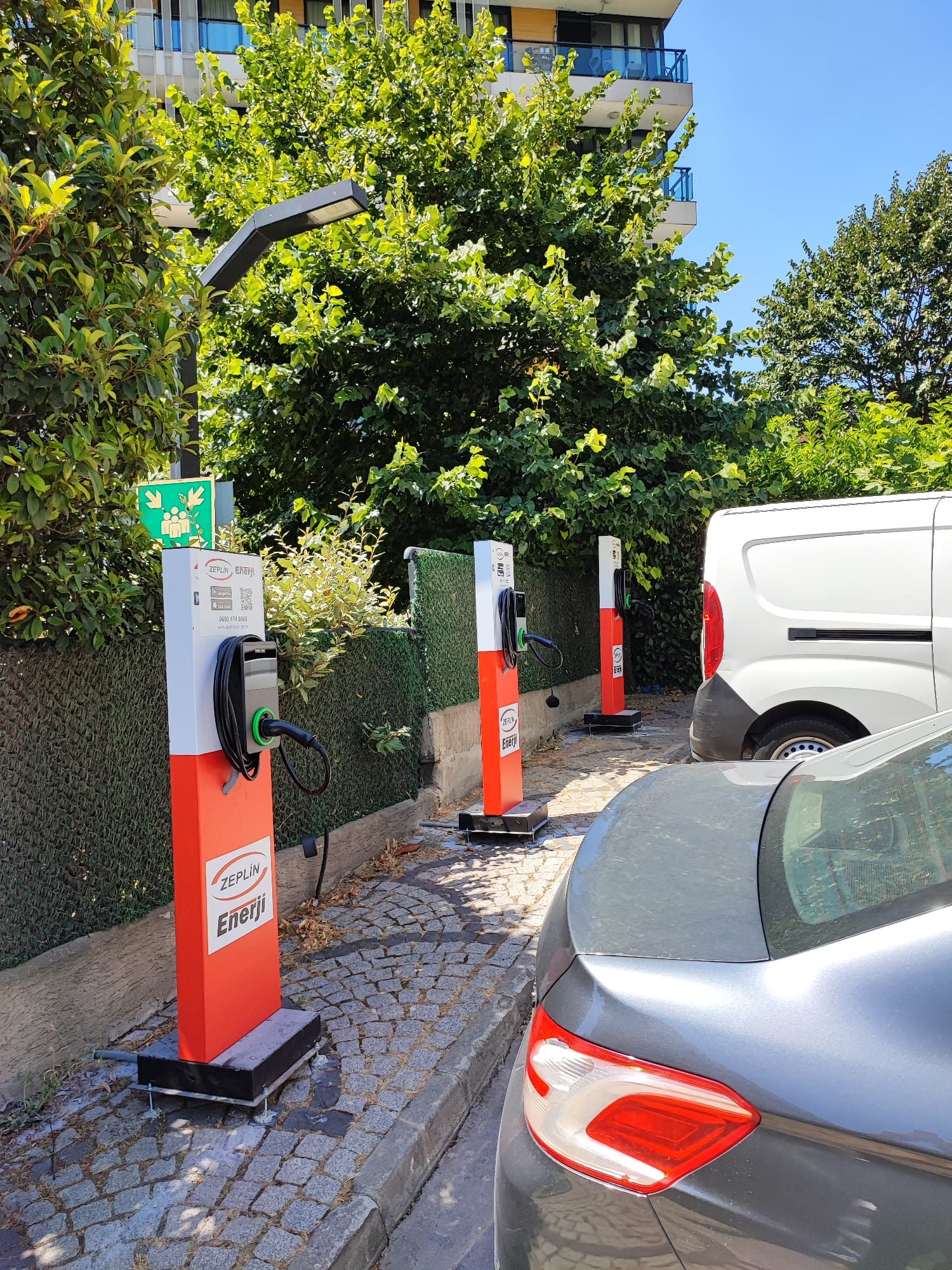 İşyeri açık otoparkında kırmızı ayaklı AC şarj cihazları