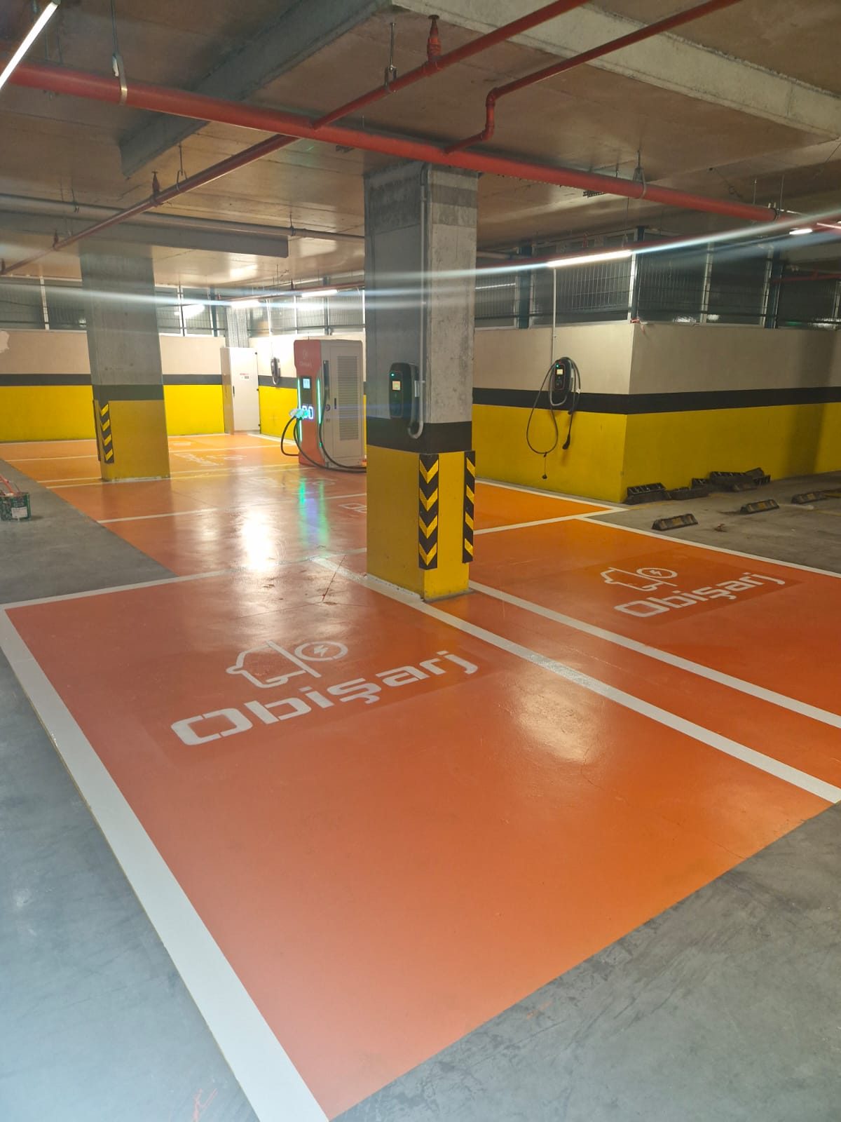 Kapalı otoparkta elektrikli araç şarjına ayrılmış turuncu park alanları